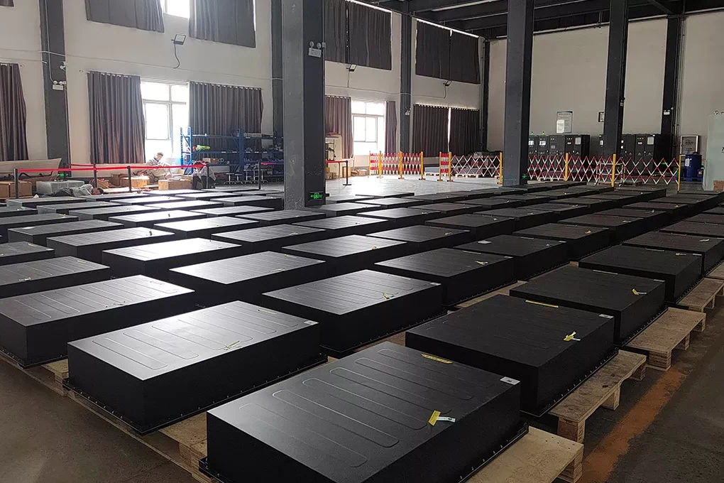 Energy storage enclosure components staged in organized production rows