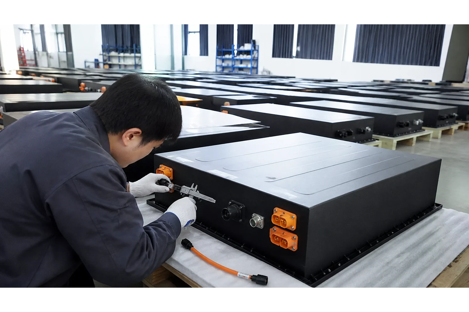 Technician checks battery modules in an organized industrial inspection bay